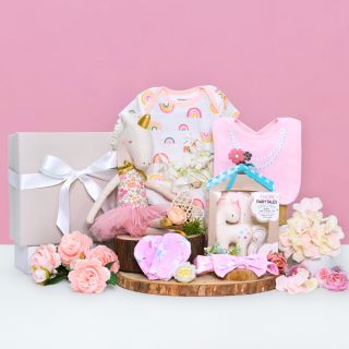 Gift set for baby girl featuring unicorn soft toy, unicorn rattle, romper, bib and mittens